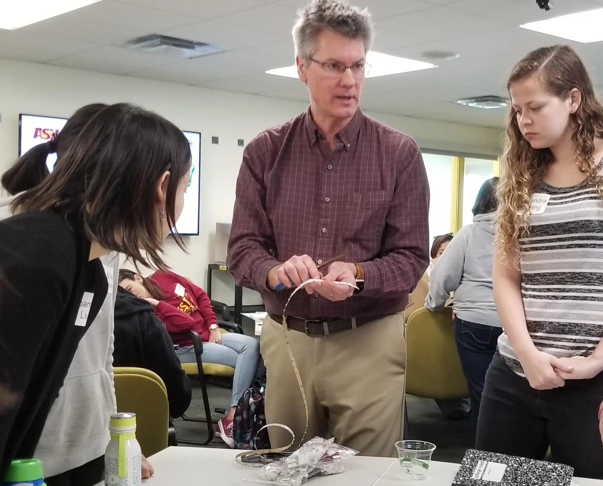 Teacher speaking to group of students in classroom